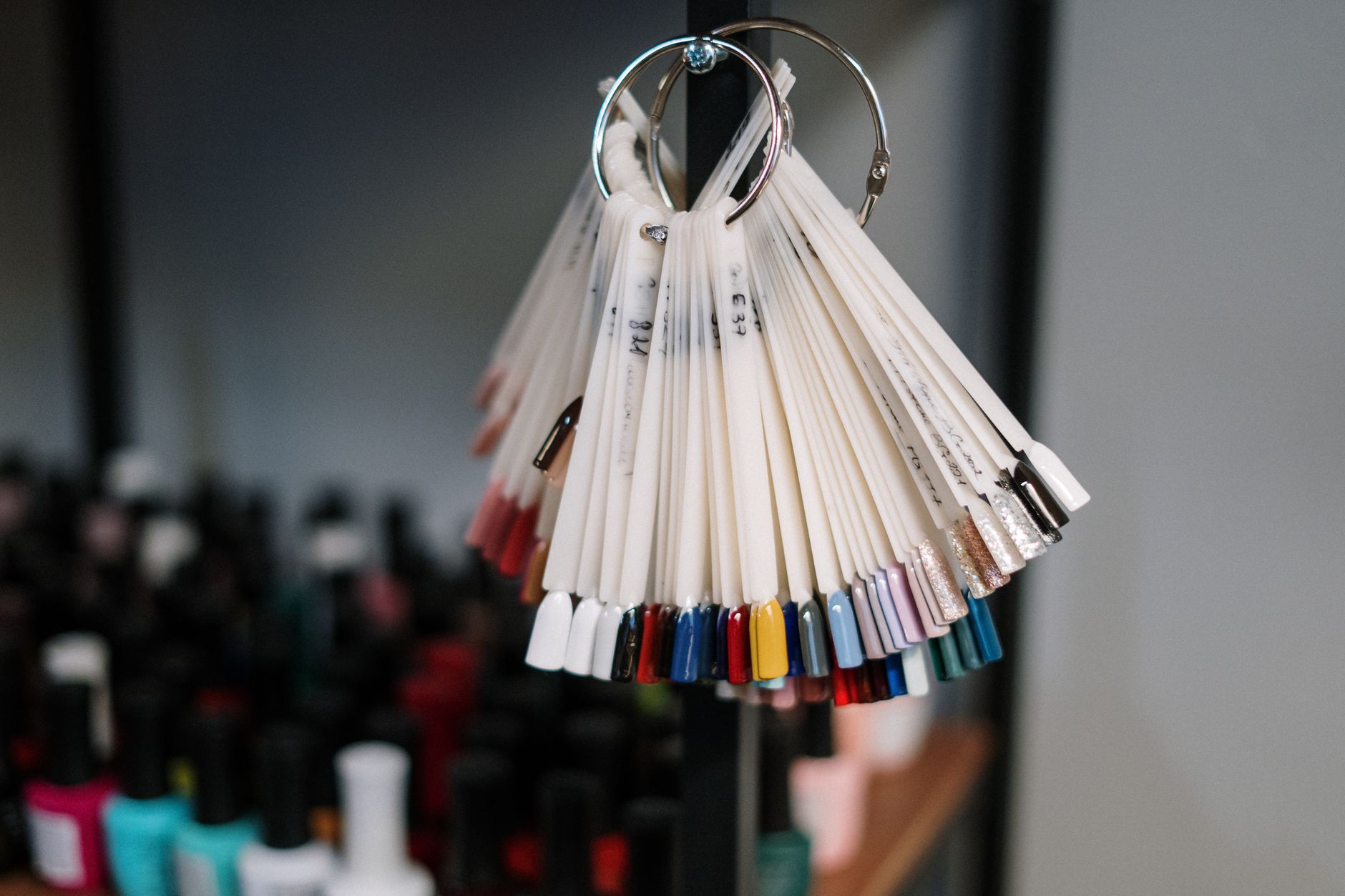 A vibrant display of nail polish swatches hanging in a beauty salon, showcasing diverse color options for manicure trends.